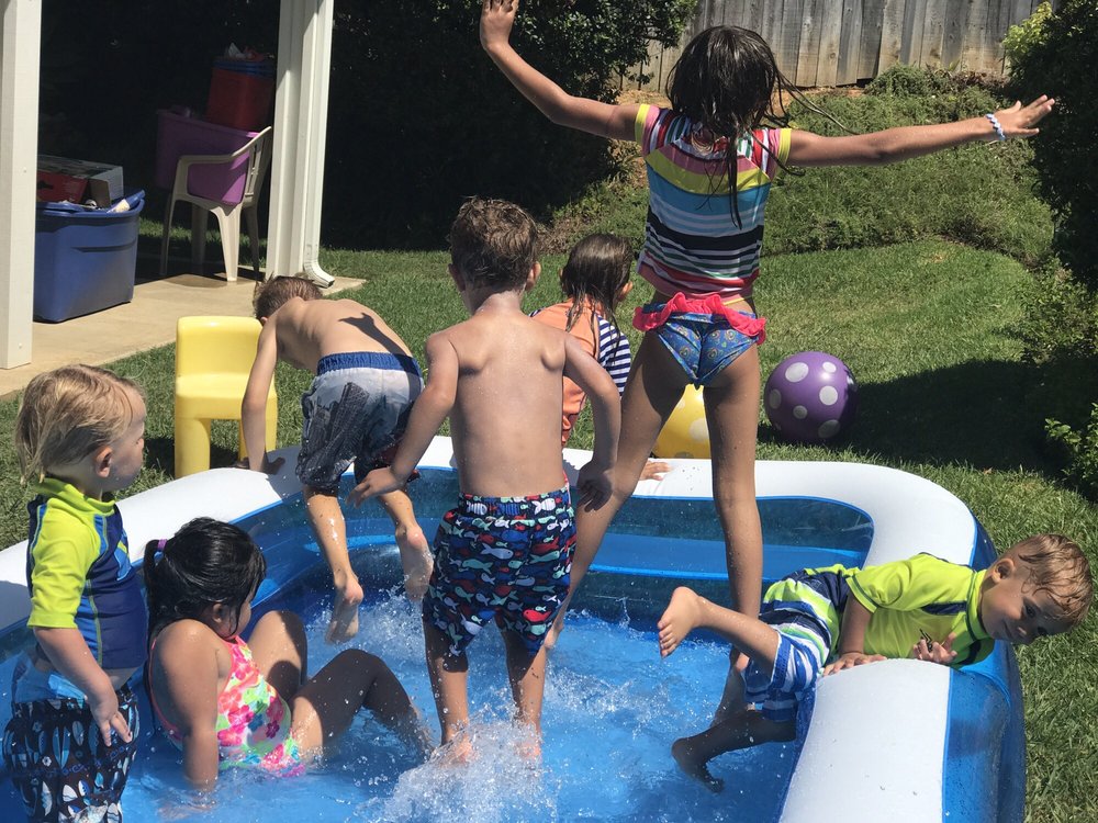 Children splashing in an inflatable pool in the backyard of Gemma's home in San Marcos