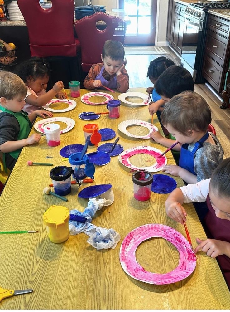 Children painting together at the table at Gemma's Family Child Care